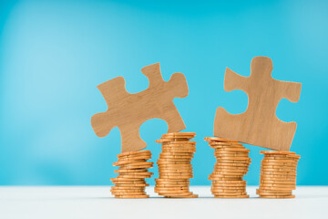 The puzzles are connected on gold coins. on a white table and blue background. Business concept idea money, office teamwork, cooperation, partnership. Banking, earnings, credit.