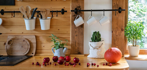 Wall Mural - Vintage rustic kitchen in a cottage with wooden wall and counter with cranberry. Kitchenware with cup and mug in cozy interior with window and plant. Banner