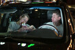 © Вячеслав Думчев - Two young people - a guy and a young woman have fun and eat a burger in the car