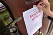 © Вячеслав Думчев - Civil servant sticks a notice of eviction of the tenant