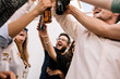 © Joseph Table - portrait of a group of friends toasting and celebrating. Everyone smiles and holds a beer each