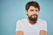© SHOTPRIME STUDIO - Bearded man emotions white t-shirt lifestyle gestures with hands blue backgrounds
