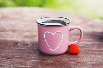 Pink mug with shape of hearts on wooden table. Big and small heart. Romantic, St Valentine's Day concept.
