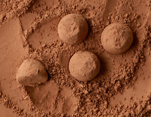 Poster - chocolate truffles on cocoa powder background