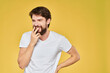 © SHOTPRIME STUDIO - Bearded man white t-shirt emotions gestures with hands fun yellow background