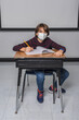 © 3Days2Go Media - Young male student with virus mask sitting and studying in classroom