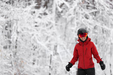 Winter Sport Happy Skier Alpine Skiing Going Dowhill Against Snow Covered Trees Background During Winter Snowstorm. Woman In Red Jacket And Goggles.