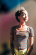 © Inti St. Clair - Portrait of teen girl with eyes closed standing in mixed rainbow light
