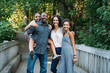 Portrait of happy mixed race family on bridge in nature park