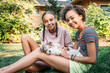 © Inti St. Clair - Sisters playing outside in yard with puppy