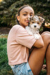 © Inti St. Clair - Portrait of girl sitting in yard hugging puppy