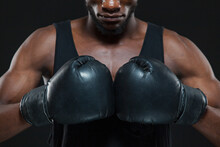 Front View Shot Of Young African American Boxer Wearing Gloves Is Posing Isolated On A Dark Background