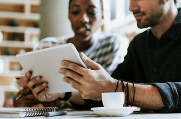 Canvas Print - Colleagues discussing their work on a tablet