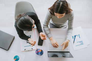 Sticker - top-down image of two Asian women working together
