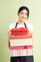 Wall Mural - Asian female waitress holding gift box
