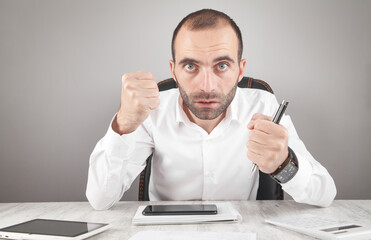 Wall Mural - Caucasian angry man looking in camera threatening with fists.