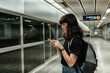 © THESHOTS.CO - Asian woman waiting for a train at metro station.