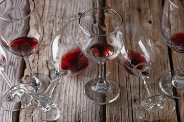 Glass with the remains of red wine on glasses lie on a rustic wooden background. Copy of the space. Alcoholic drinks concept.