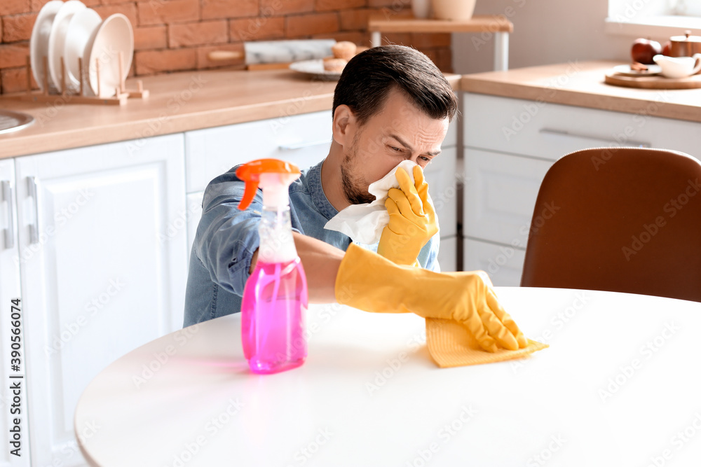 Allergic man cleaning his flat