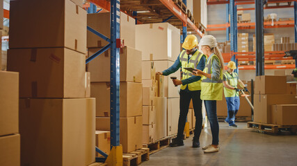 Wall Mural - Retail Warehouse full of Shelves with Goods in Cardboard Boxes, Male Worker and Female Supervisor Holding Digital Tablet Discuss Product Delivery while Scanning Packages.Distribution Logistics Center