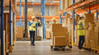 © Gorodenkoff - Handsome Male Worker Wearing Hard Hat Holding Digital Tablet Computer Walking Through Retail Warehouse full of Shelves with Goods, Greeting Workers. Working in Logistics and Distribution Center.