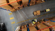 © Gorodenkoff - Top-Down View: Worker Moves Cardboard Boxes using Hand Pallet Truck, Walking between Rows of Shelves with Goods in Retail Warehouse. People Work in Product Distribution Logistics Center