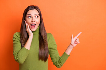 Sticker - Photo of young attractive happy shocked amazed girl hold hand cheek point finger copyspace isolated on orange color background