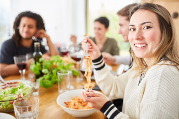 Wall Mural - Freunde essen gemeinsam Spaghetti mit Tomatensauce in WG