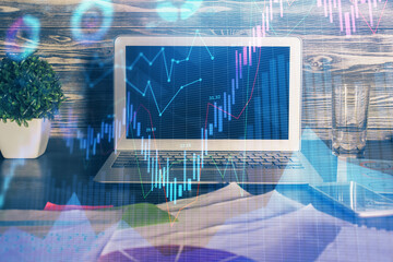 Double exposure of graph and financial info and work space with computer background. Concept of international online trading.