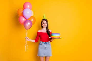 Sticker - Photo of cute charming cheerful young girl shiny smiling hold many balloons cake birthday concept wear cone shirt open shoulders denim skirt isolated bright yellow color background