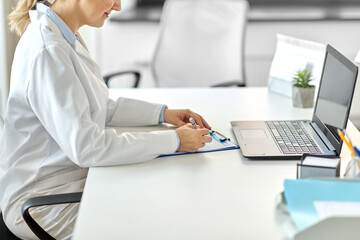 Poster - medicine, healthcare and profession concept - female doctor in white coat with laptop computer and medical report at hospital