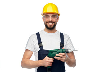 profession, construction and building - happy smiling male worker or builder in helmet and goggles with drill over white background