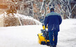 © Tricky Shark - Worker with motorized track drive snowblower clears deep snow, heavy duty assistant for snow and ice removal in winter season. Motor machine for removing wet, heavy snow. Snowthrower equipment