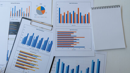 Blue graphs and charts Lots of business reports and papers on the table.