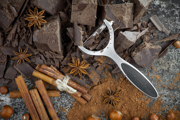 Pieces of dark chocolate and cocoa beans in composition on old background