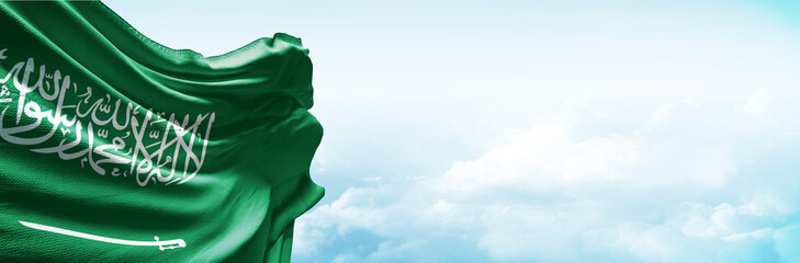 Saudi arabia flag in the blue sky. Horizontal panoramic banner.