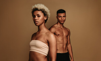 african american man and woman standing on brown background