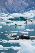 Sea Kayaker Paddling In Glacial Lagoon At A Glacier Terminus On The Coast Of Alaska