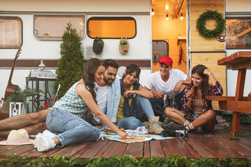 Poster - Young travelers with world map planning trip near motorhome