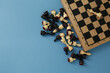 © Qwenergy - Chess pieces and board on a blue background
