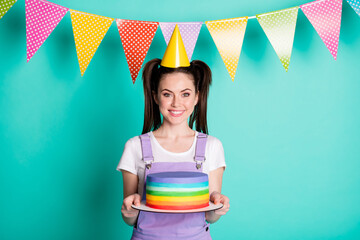 Sticker - Photo portrait of cheerful happy birthday girl wearing yellow cone keeping colorful cake isolated on bright turquoise color background