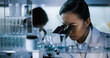 © Marcin Janiec - Female doctors testing samples in futuristic laboratory. Using microscopes and computer with data