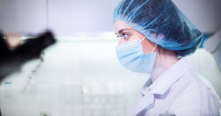 Wall Mural - female doctor working in futuristic laboratory. wearing protective workwear for biohazardous sample 