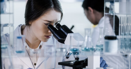 Wall Mural - female doctors testing samples in futuristic laboratory. using microscopes and computer with data