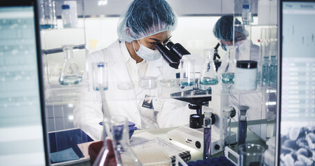 Wall Mural - female science team working on biohazardous samples. using microscope and computer with data