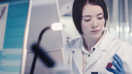 Wall Mural - modern laboratory. female scientist working with microscope. testing blood samples