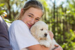 © Mint Images - teen age girl holding a English golden retriever puppy