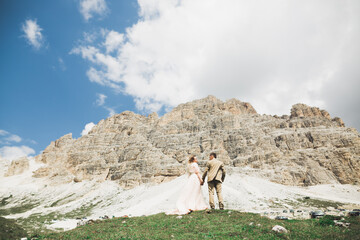 Wall Mural - Loving husband and woman on the background of the mountains. Loving couple emotionally spends time