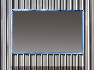 Wall Mural - Empty sign mounted metal paneled wall.