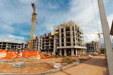 reinforced frame in the foreground of a new monolithic house under construction against a blue sky